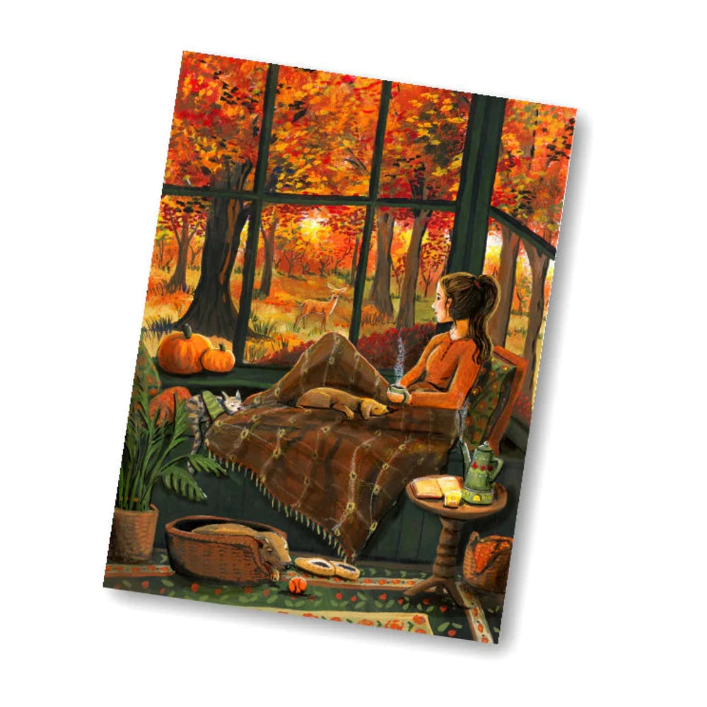Postkarte Herbstfenster von Esther Bennink A6: eine junge Frau entspannt im Wintergarten mit Blick auf leuchtendes Herbstlaub, Kürbisse stehen davor
