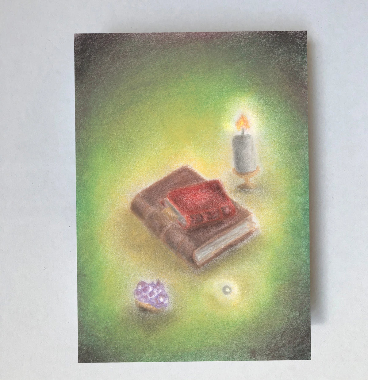 Postkarte Bücher von Lot Bouwes A6: ein altes Märchenbuch liegt im Licht einer Kerze, daneben ein kleiner Kristall