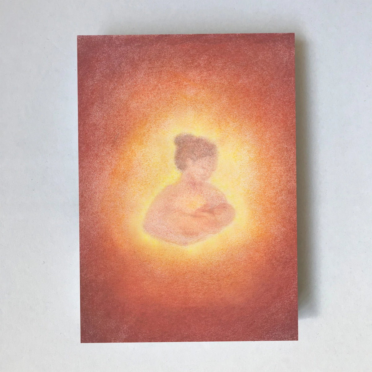 Postkarte Stillen von Lot Bouwes A6: eine Mutter stillt ihr Baby, warm umhüllt von orangem Licht