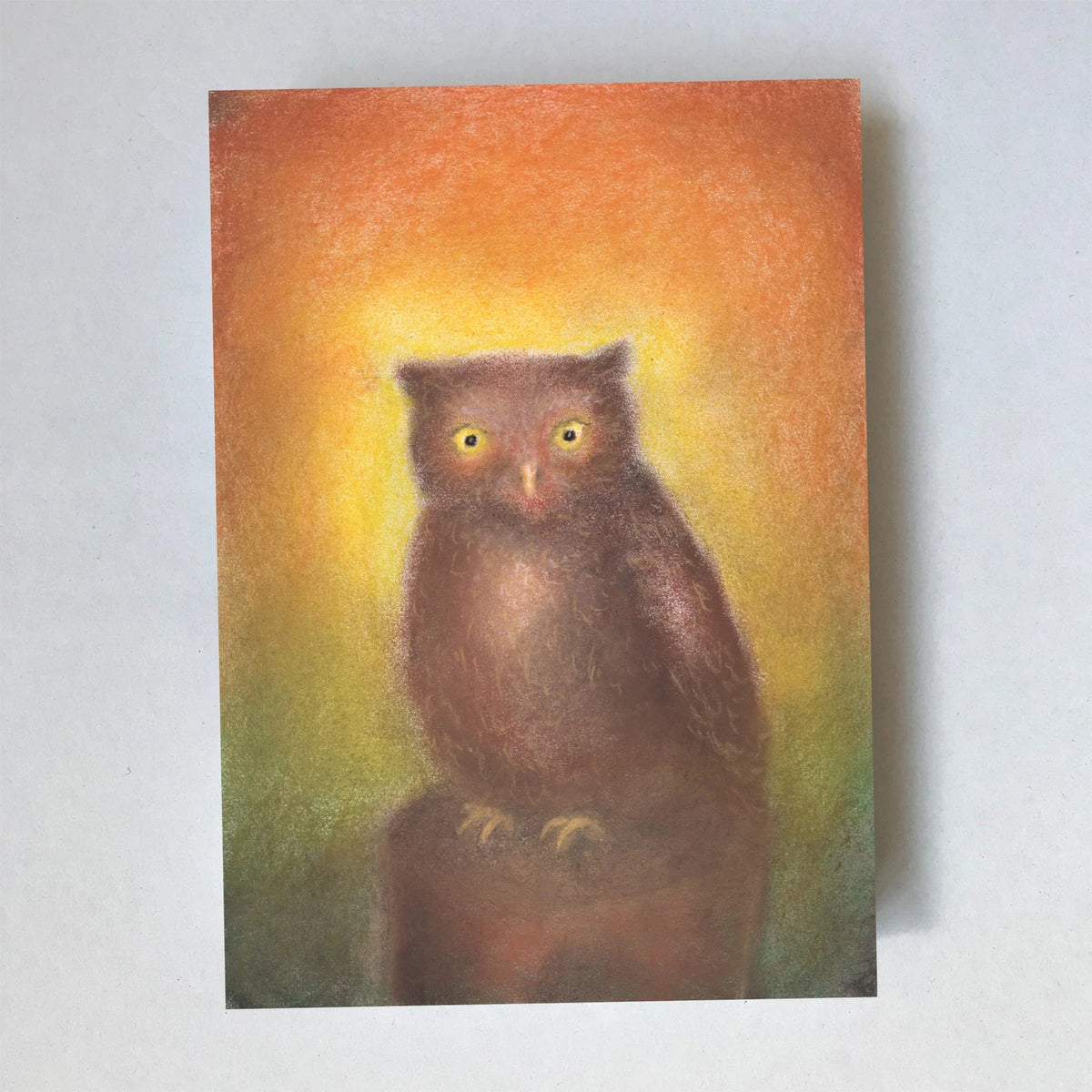 Postkarte Uhu von Lot Bouwes A6: ein Uhu sitzt auf einem Baumstumpf vor warmem Orange