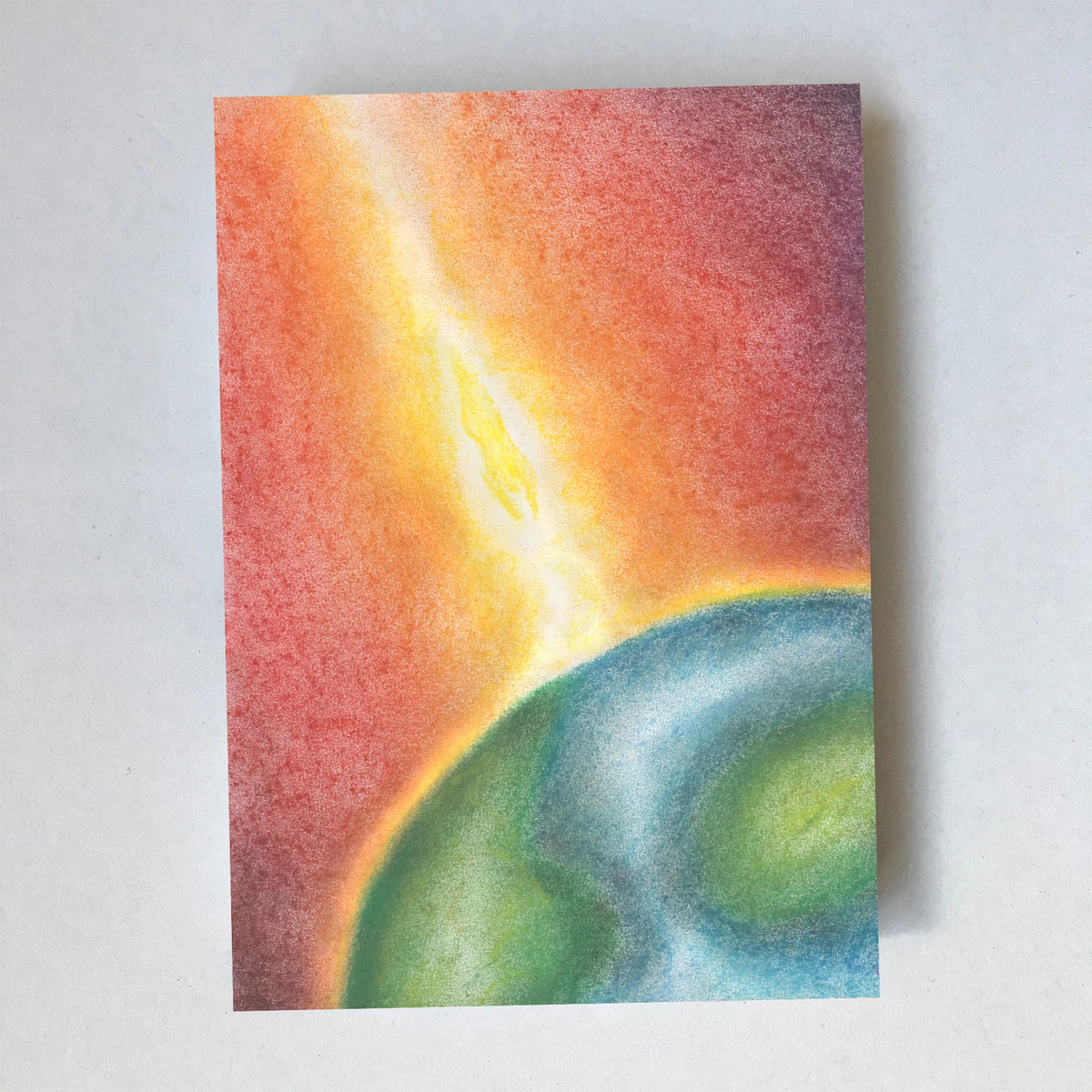 Postkarte Welt von Lot Bouwes A6: die Erde als Kugel im Weltall, ein Strahl aus goldenem Licht fällt auf sie