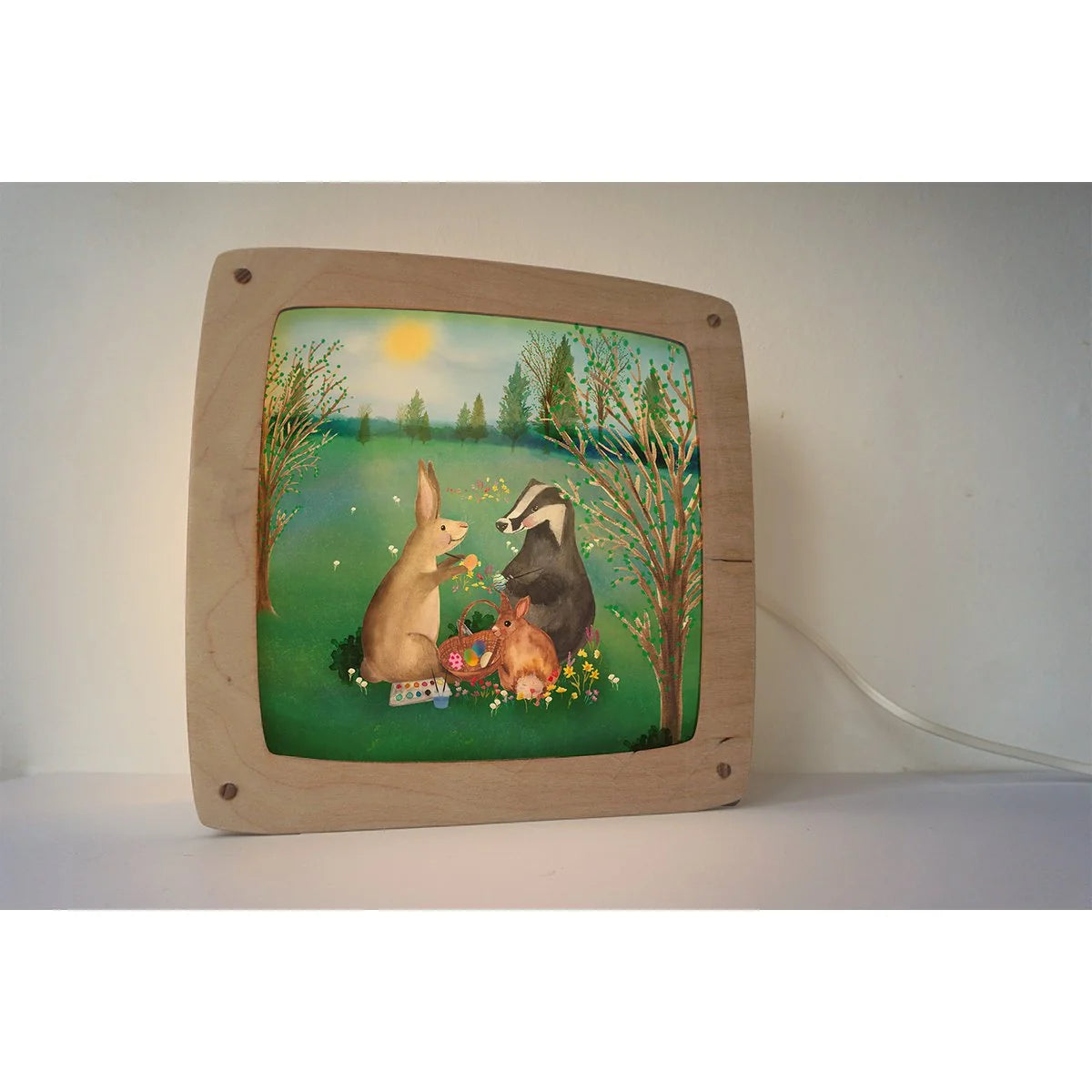 Lotte Drouen Motiv Ostern in der magischen Lampe, Hase und Dachs bemalen Ostereier auf einer Frühlingswiese