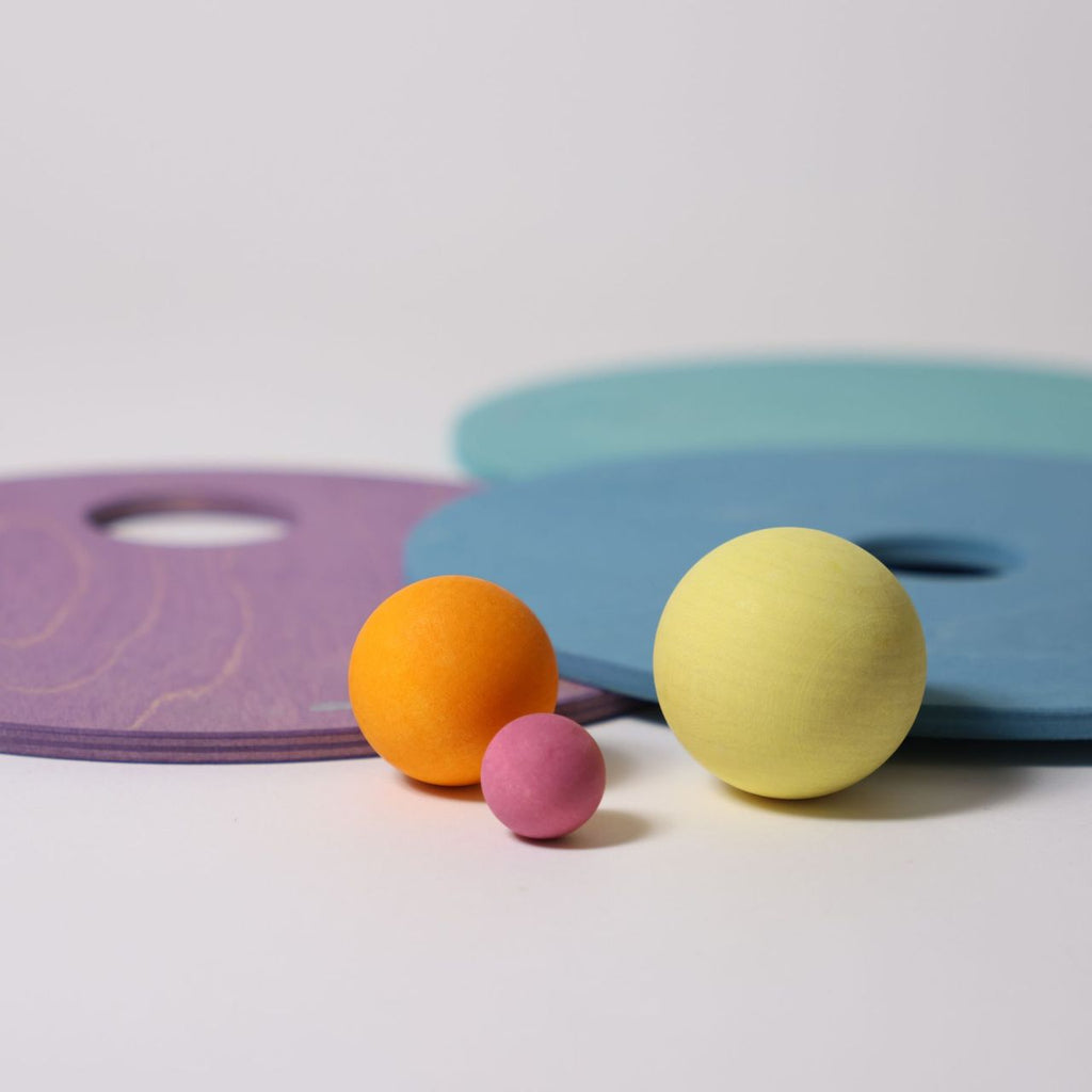 Grimm's x Stapelstein Kullerscheiben Cool Pastell, das Set und Stapelstein enthält drei Kullerscheiben in kühlen Pastelltönen mit verschieden großen Löchern und drei Holzkugeln