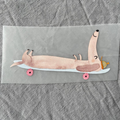 Bügelbild - Dackel auf Skateboard liegend