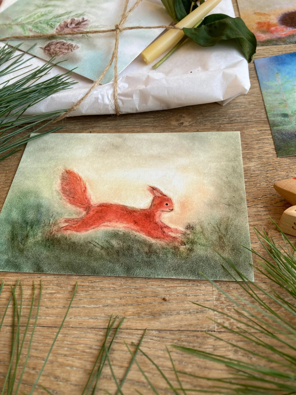 Postkarte Eichhörnchen von Andrea Reiß: rotbraunes Eichhörnchen auf einer grünen Wiese, Ansicht 2