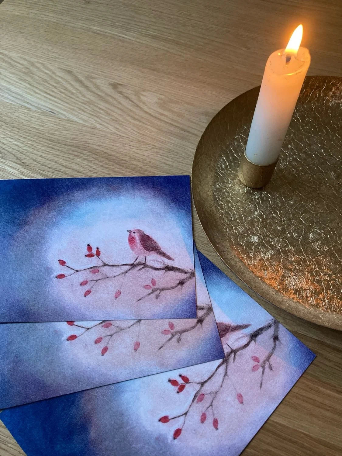 Postkarte Vögelchen von Andrea Reiß: Rotkehlchen auf einem Hagebuttenzweig vor blauem Hintergrund, Ansicht 3