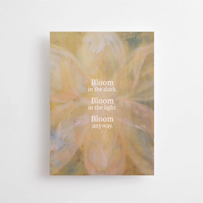 Postkarte Bloom in the dark. Bloom in the light. Bloom anyway. von Anna Cosma A6: eine Karte mit einer weich gemalten Blüte in Gold und Rosé und dem Schriftzug „Bloom in the dark. Bloom in the light. Bloom anyway.“