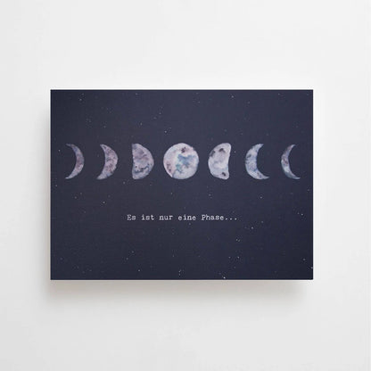 Postkarte Es ist nur eine Phase von Anna Cosma A6: eine dunkelblaue Karte im Querformat mit einer Reihe von Mondphasen und dem Schriftzug „Es ist nur eine Phase…“
