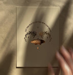 Postkarte „Let the old go, so the new can grow“ von Anna Cosma A6, in der Hand im Sonnenlicht