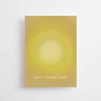 Postkarte „Make of yourself a light“ von Anna Cosma A6: eine gelbe Karte mit leuchtendem Sonnenkreis und dem Schriftzug „Make of yourself a light“