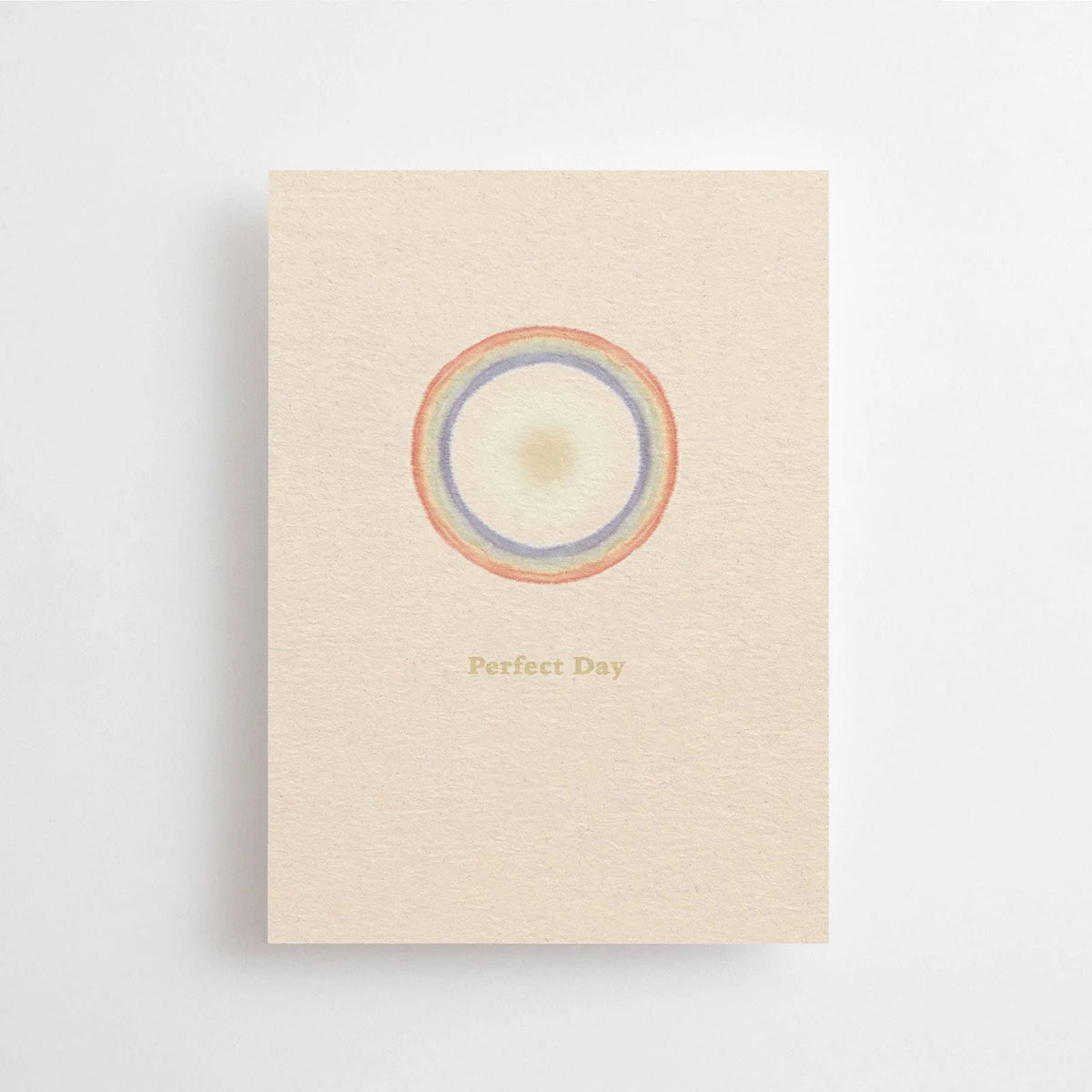 Postkarte Perfect Day von Anna Cosma A6: eine beige Karte mit einem Kreis aus Regenbogenringen und dem Schriftzug „Perfect Day“