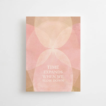 Postkarte Time expands when we slow down von Anna Cosma A6: eine rosafarbene Karte mit sanften Bogenformen wie eine Sanduhr und dem Schriftzug „Time expands when we slow down“