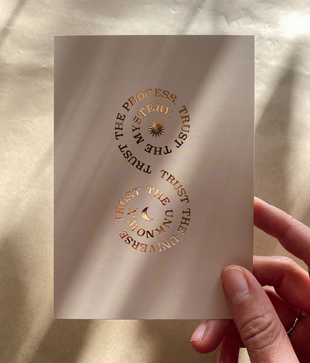 Postkarte „Trust the process“ von Anna Cosma A6, in der Hand im Sonnenlicht