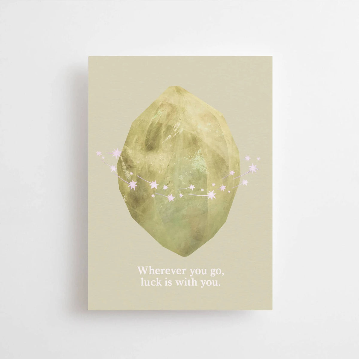 Postkarte Wherever you go, luck is with you von Anna Cosma A6: eine graugrüne Karte mit einer goldgrün schimmernden Form, kleinen Sternen und dem Schriftzug „Wherever you go, luck is with you“