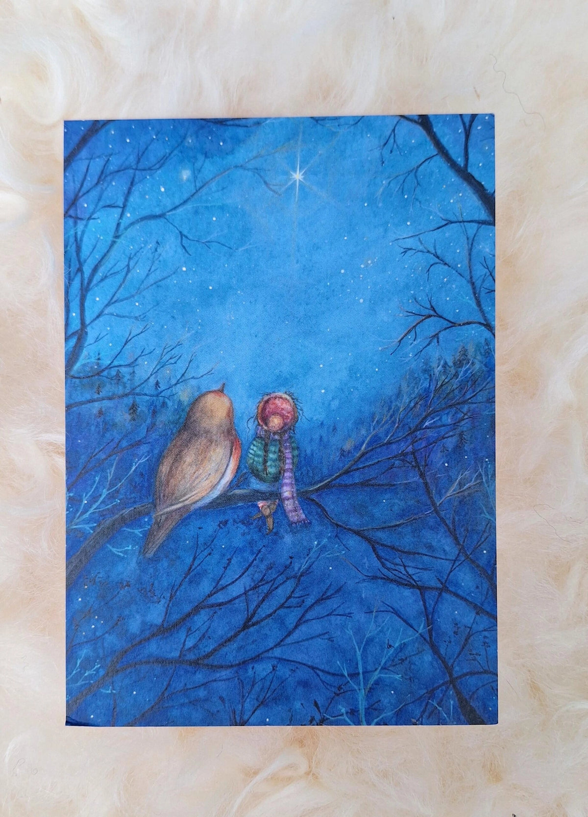 Postkarte Sternenfunkeln von Anne Gies A6: ein Rotkehlchen und ein kleiner Wichtel mit roter Mütze sitzen auf einem Ast unter einem tiefblauen Sternenhimmel