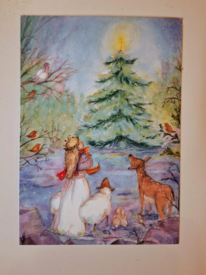 Postkarte Weihnachten von Anne Gies A6: Menschen und Tiere, darunter ein Schaf und ein Reh, versammeln sich im Schnee um einen geschmückten Tannenbaum mit leuchtendem Stern, ringsum kleine Vögel