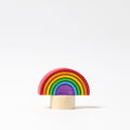 Grimm's Steckfigur Regenbogen, der kleine Regenbogen leuchtet in allen Farben auf seinem Holzfuß