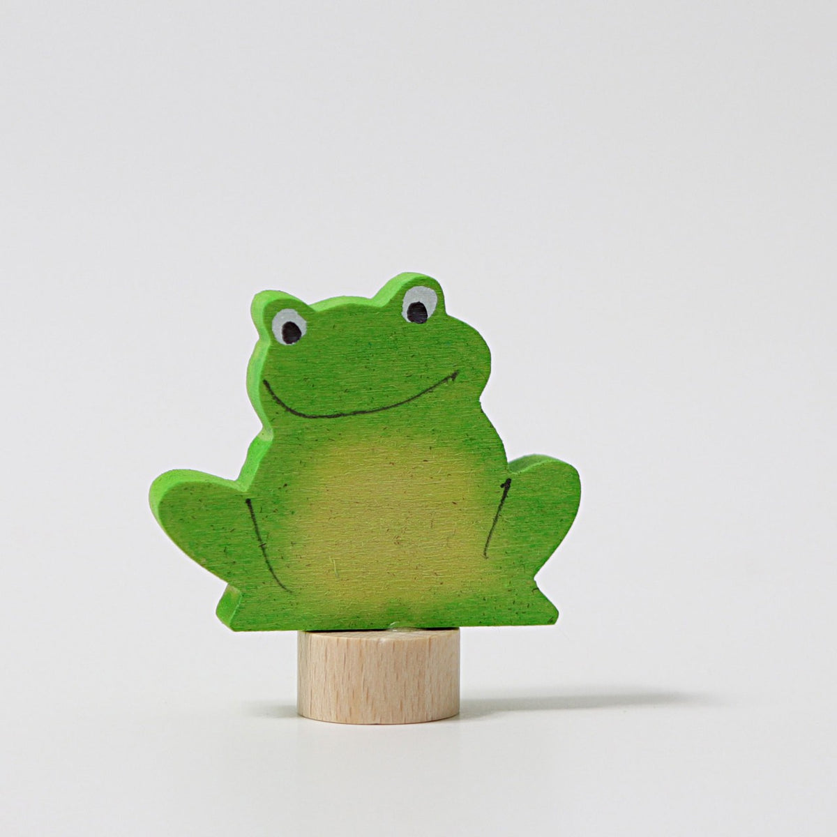 Grimm's Steckfigur Frosch, der grüne Frosch sitzt breit lächelnd auf seinem Holzfuß