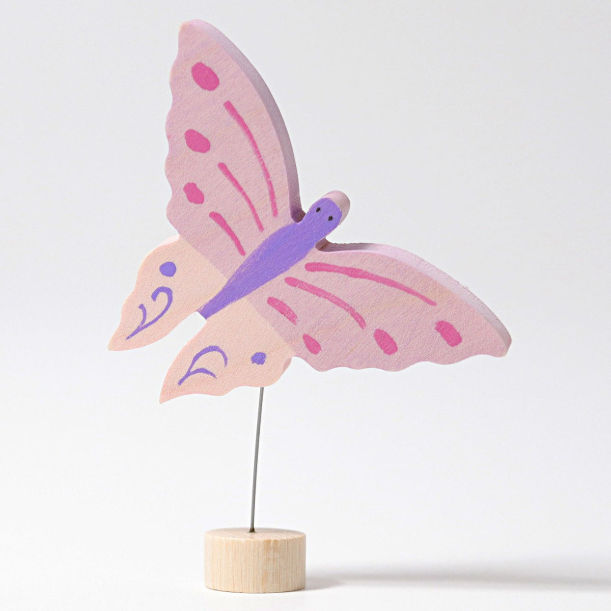 Grimm's Steckfigur Schmetterling rosa, der rosa Schmetterling schwebt an einem feinen Stab über seinem Holzfuß