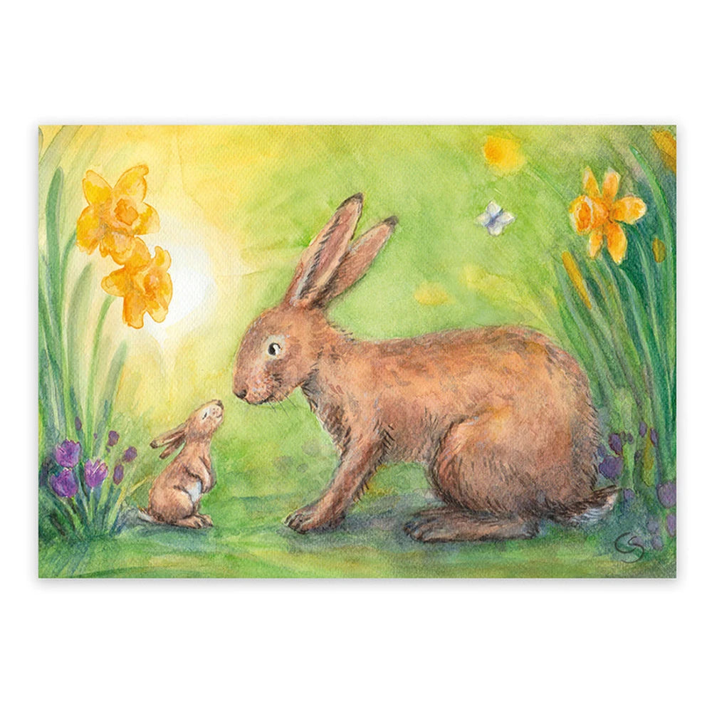 Postkarte Kleiner und großer Hase von Corinna Schwerdtfeger A6: ein großer und ein kleiner Hase stupsen sich mit der Nase an, ringsum Osterglocken und Krokusse im Sonnenlicht