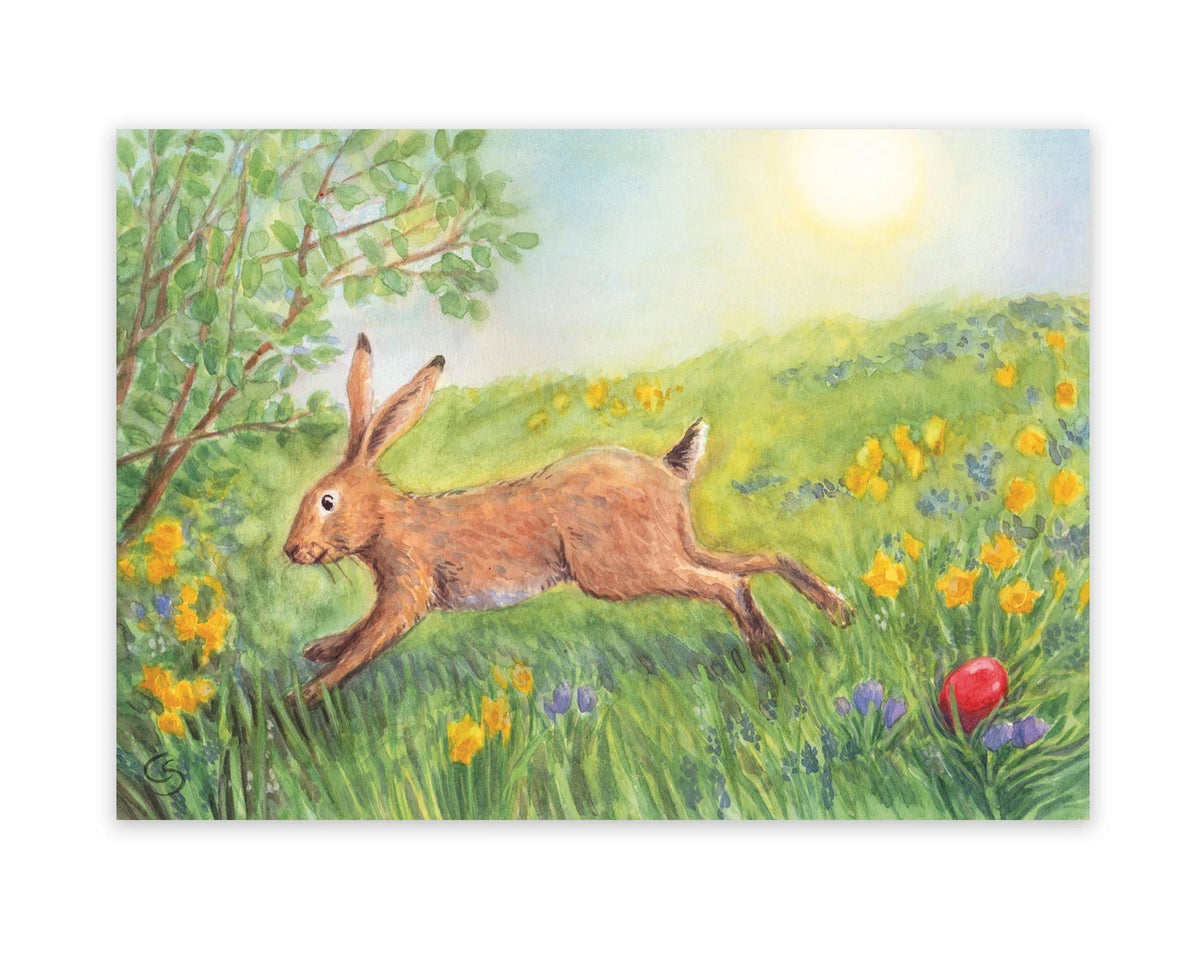 Postkarte Ostermorgen von Corinna Schwerdtfeger A6: ein Hase springt über eine Frühlingswiese mit gelben Blumen, im Gras liegt ein rotes Ei, die Sonne scheint