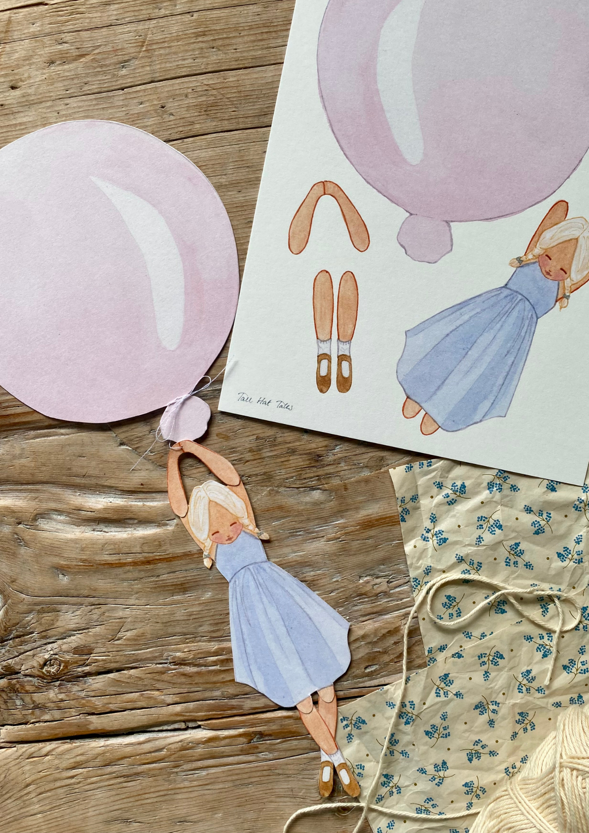 Bastelbogen Mobile Mädchen mit rosa Ballon von Tall Hat Tales, Bogen und ausgeschnittenes Mädchen am rosa Ballon auf Holz