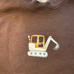 Bügelbild Bagger von doerrtoparadise aufgebügelt auf einem braunen Pullover