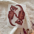 Bügelbild Otter von doerrtoparadise, zwei Otter halten sich an den Pfoten