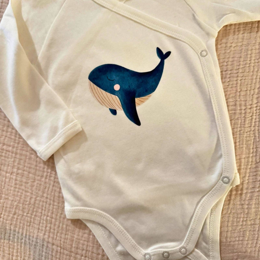 Bügelbild Wal von doerrtoparadise aufgebügelt auf einem cremefarbenen Babybody