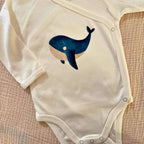 Bügelbild Wal von doerrtoparadise aufgebügelt auf einem cremefarbenen Babybody