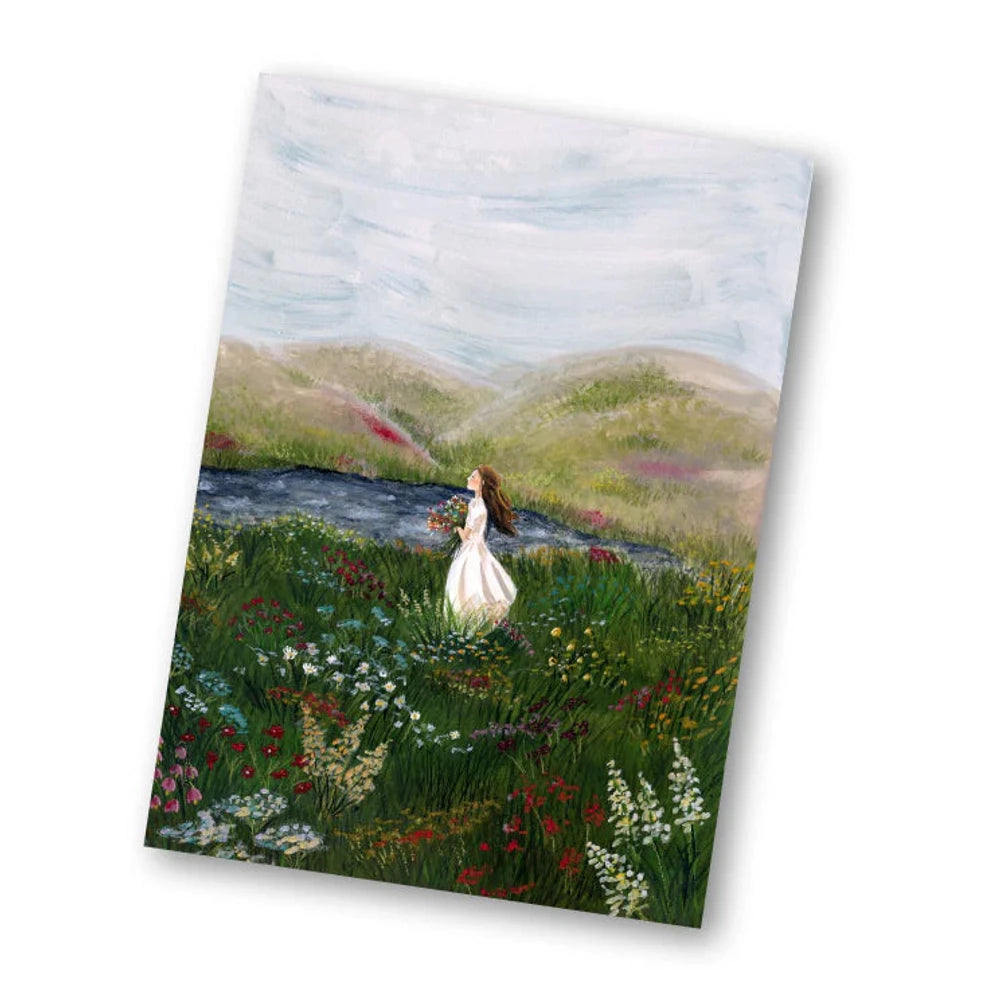 Postkarte Seebrise von Esther Bennink A6: eine weiße Gans steht auf einer grünen Wiese am Meer, dahinter Hügel