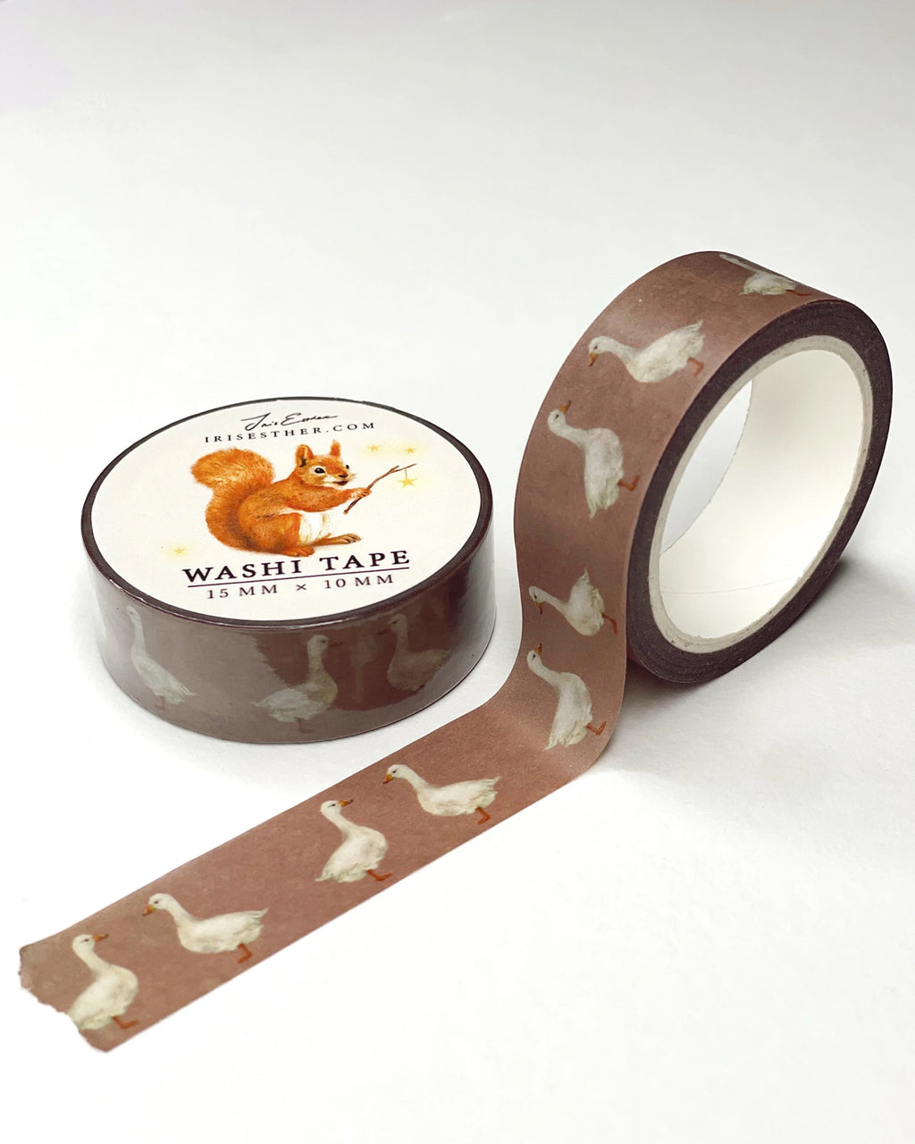Washi Tape Gänse von Iris Esther, Rolle mit abgerolltem Band, weiße Gänse auf warmem Braun