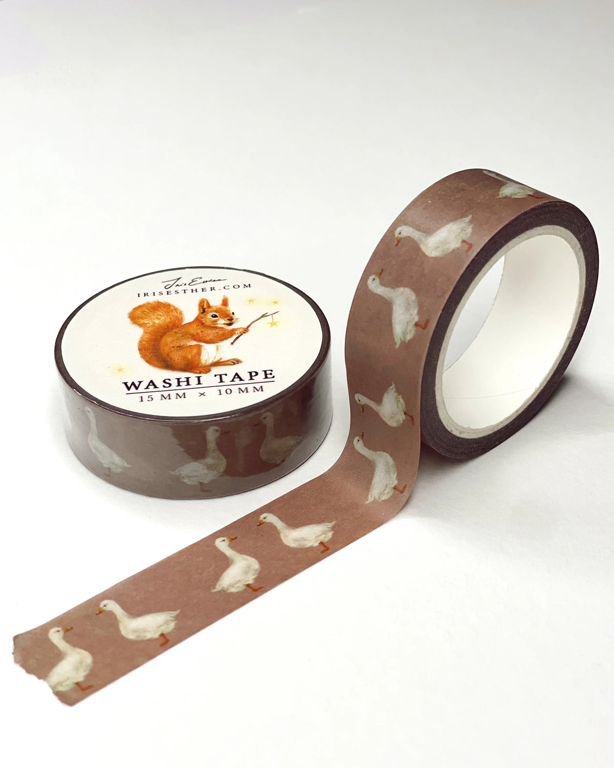 Washi Tape Gänse von Iris Esther, Rolle mit abgerolltem Band, weiße Gänse auf warmem Braun