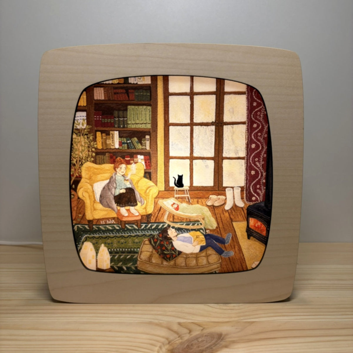 Motiv Im Winterhäuschen von Goose Grass Illustrations in der magischen Lampe, gemütliche Stube mit Bücherregal, Ofen und Sessel, ein Kind liest auf dem Teppich, schwarze Katze am Fenster