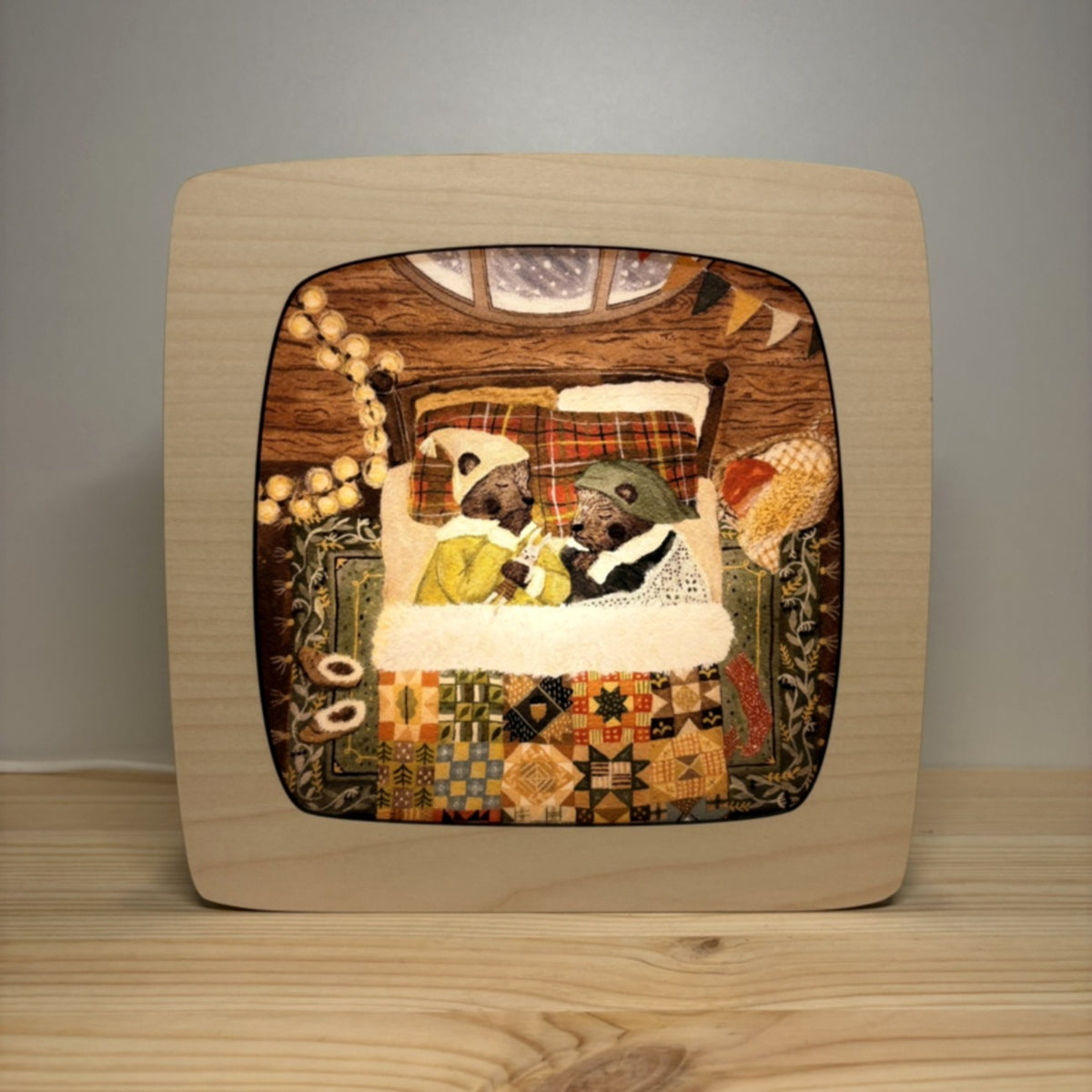 Motiv Winterschlaf von Goose Grass Illustrations in der magischen Lampe, zwei Tiere schlafen in einer gemütlichen Höhle unter einer bunten Flickendecke