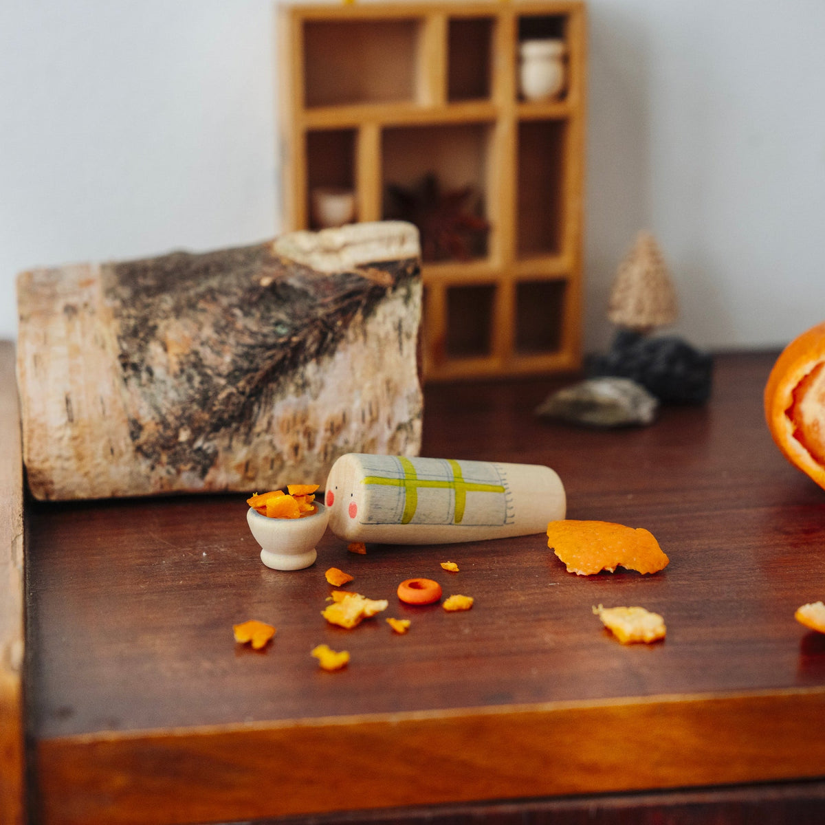 Grapat Adventskalender 2026, kleine Spielwelt mit Holzstamm und orangen Teilen auf dem Tisch