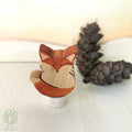 Stecker Fuchs von Hamer & Zaag, eingerollter orangeroter Fuchs neben einem Tannenzapfen