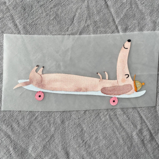 Bügelbild - Dackel auf Skateboard liegend