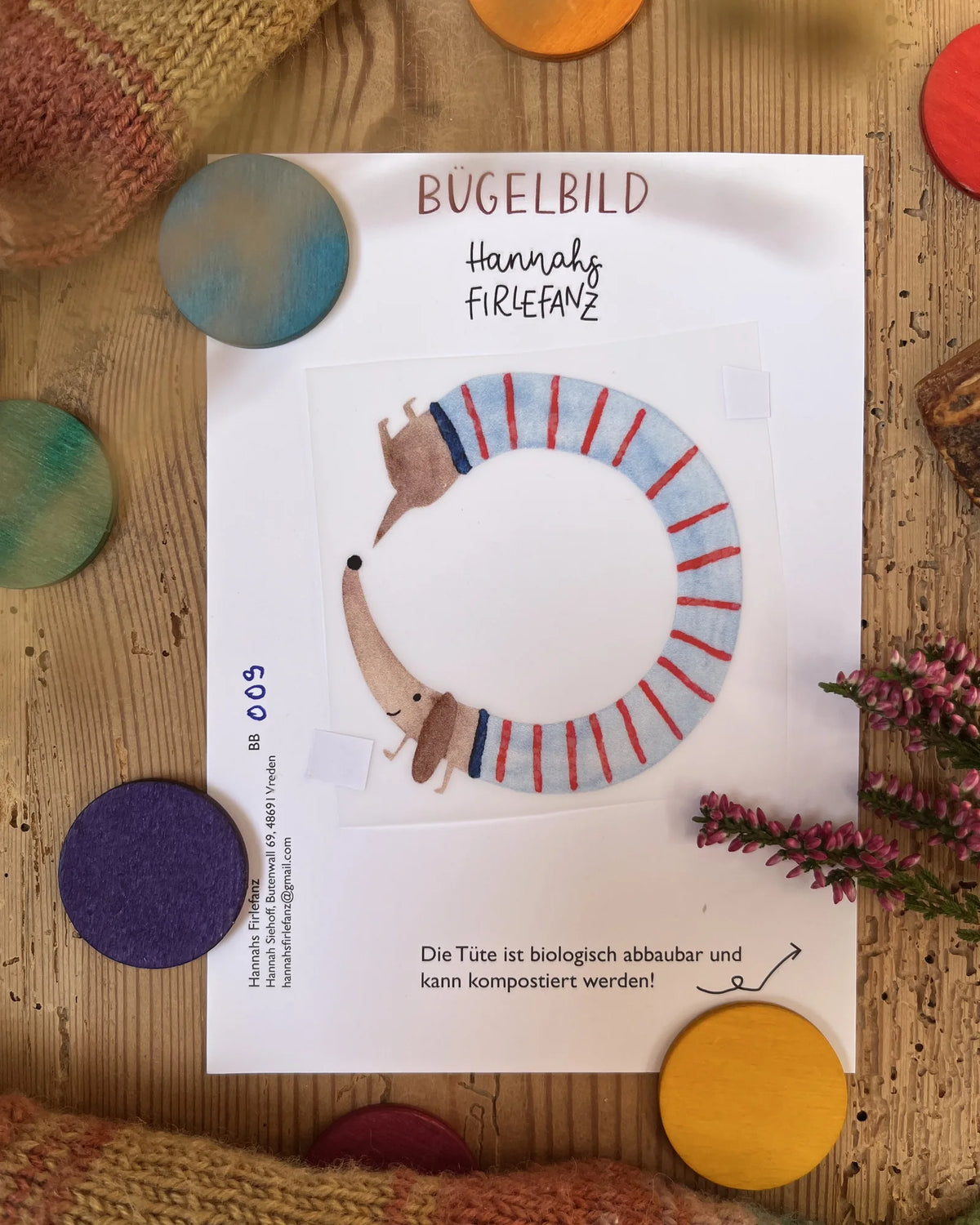 Hannahs Firlefanz Bügelbild Dackel im Ringelpulli, zum Kreis gerollt, auf der Bügelbild-Karte in der Tüte
