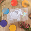 Hannahs Firlefanz Bügelbild grauer Elefant mit Schultüte im Rüssel, auf Holz zwischen bunten Holzscheiben