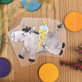 Hannahs Firlefanz Bügelbild grauer Esel mit bunter Schultüte, auf Holz zwischen bunten Holzscheiben