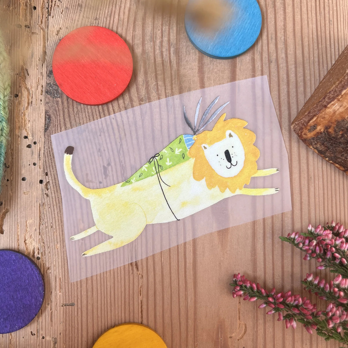 Hannahs Firlefanz Bügelbild springender Löwe mit grüner Schultüte, auf Holz zwischen bunten Holzscheiben