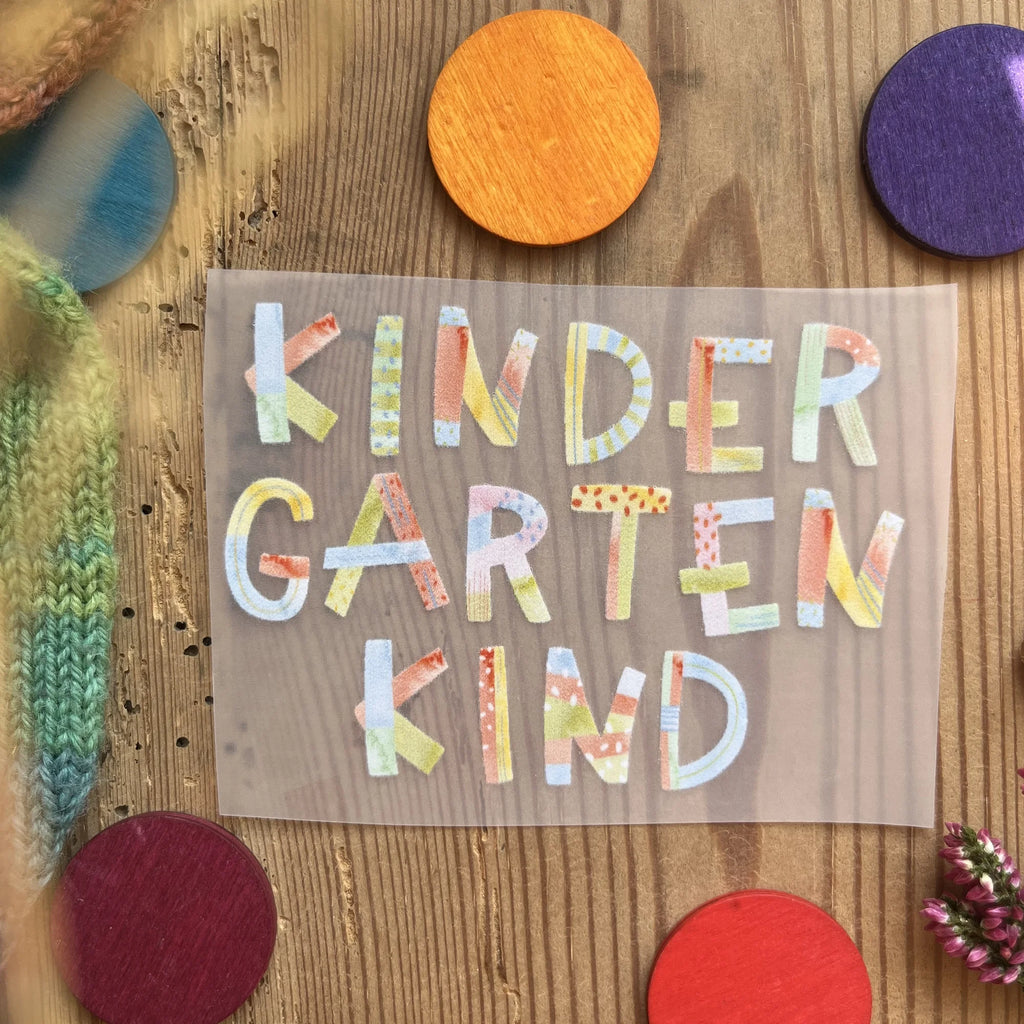 Hannahs Firlefanz Bügelbild Schriftzug Kindergartenkind in bunten Buchstaben, auf Holz zwischen bunten Holzscheiben