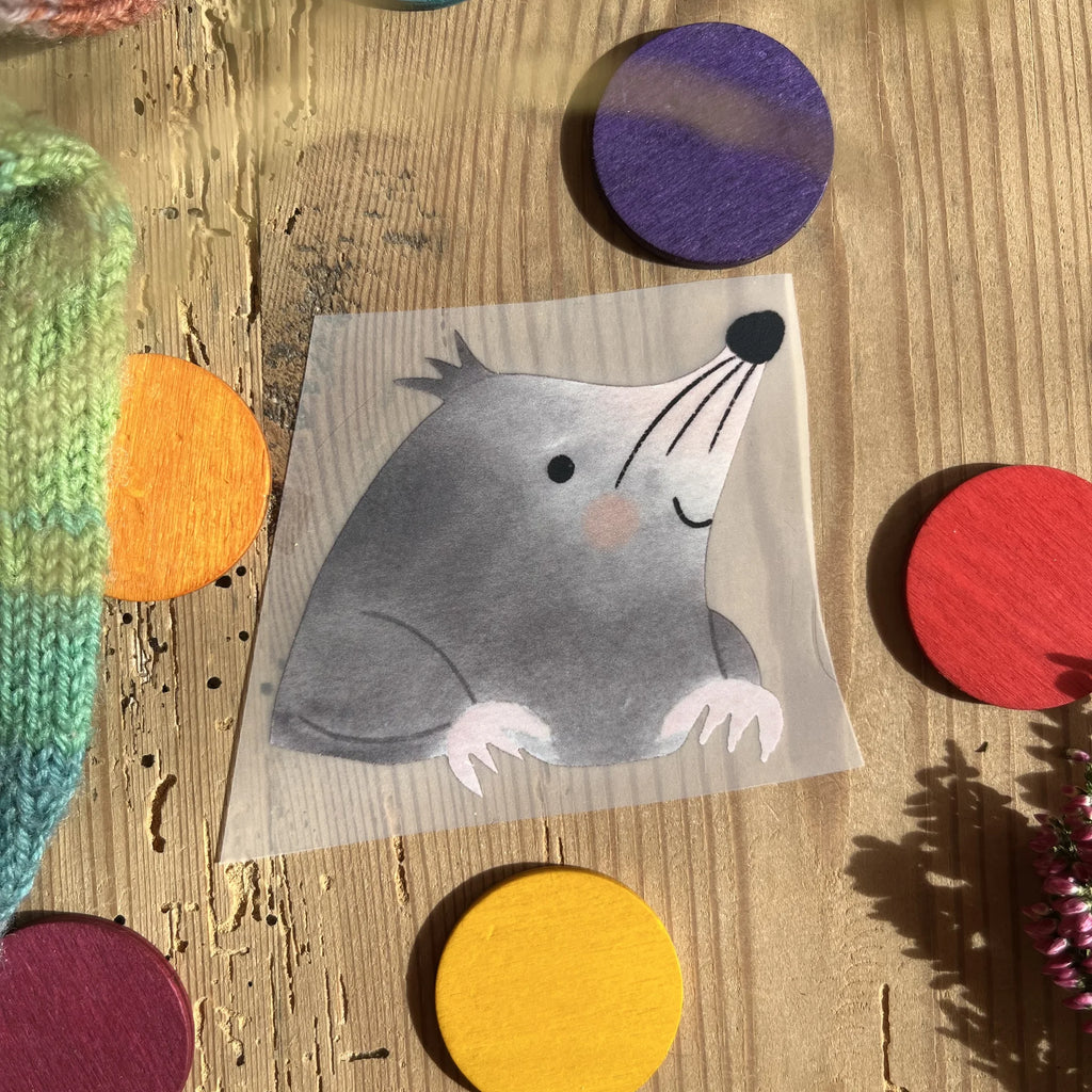 Hannahs Firlefanz Bügelbild Maulwurf, der aus der Erde schaut, auf Holz zwischen bunten Holzscheiben
