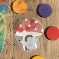 Hannahs Firlefanz Bügelbild Maus unter einem Fliegenpilz, auf Holz zwischen bunten Holzscheiben