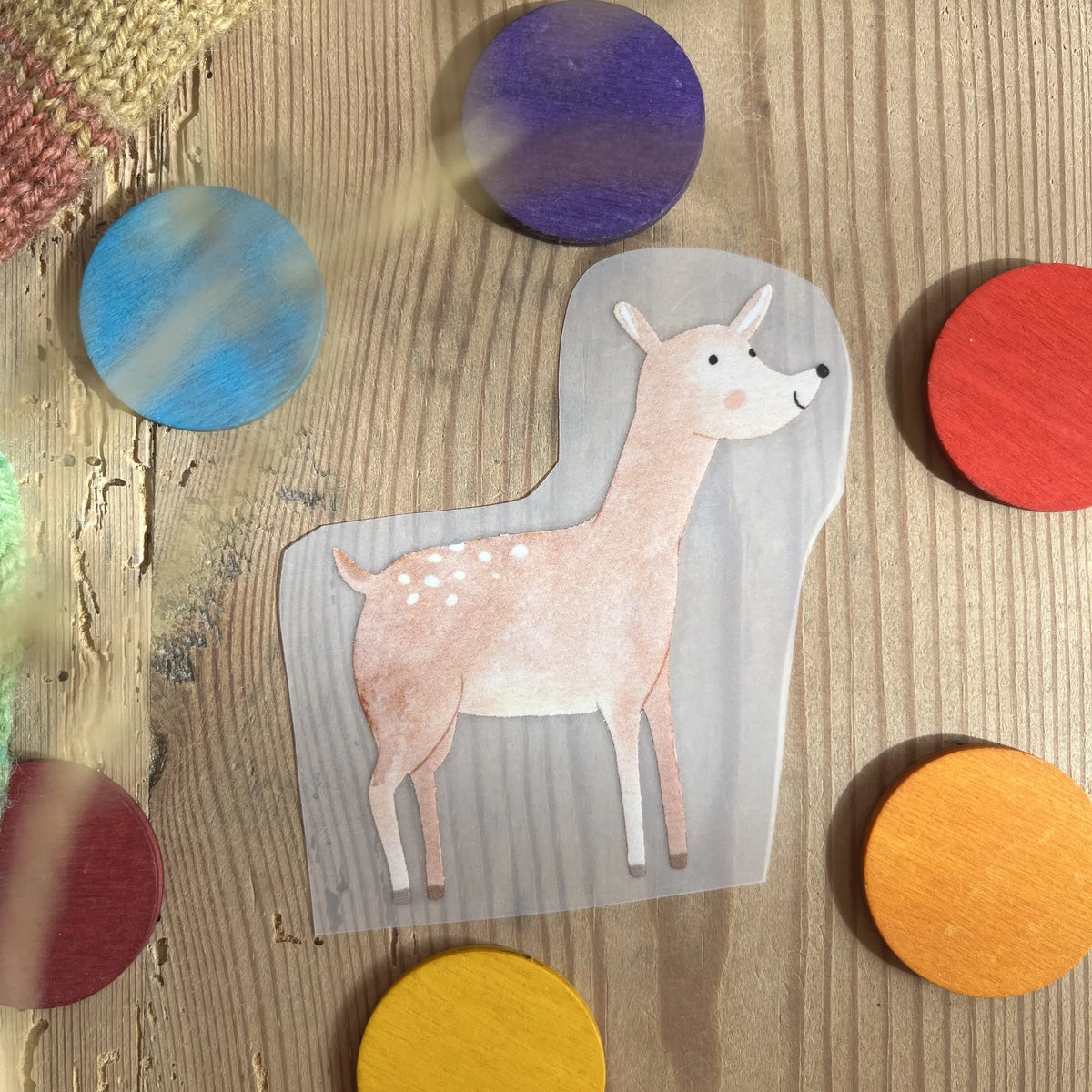 Hannahs Firlefanz Bügelbild Rehkitz mit weißen Punkten, auf Holz zwischen bunten Holzscheiben