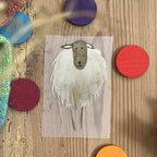 Hannahs Firlefanz Bügelbild zotteliges Schaf, auf Holz zwischen bunten Holzscheiben