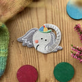 Hannahs Firlefanz Patch Elefantenkopf mit bunter Mütze, gestickt, auf Holz zwischen bunten Holzscheiben