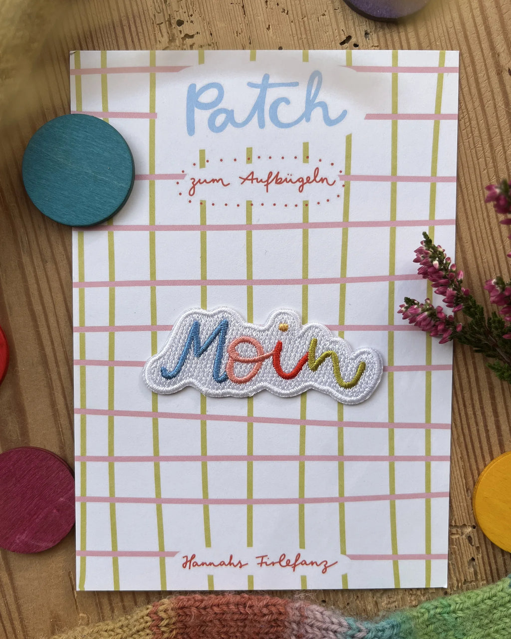 Hannahs Firlefanz Patch Schriftzug Moin in Regenbogenfarben, auf der karierten Karte Patch zum Aufbügeln