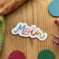 Hannahs Firlefanz Patch Schriftzug Moin in Regenbogenfarben, gestickt, auf Holz zwischen bunten Holzscheiben